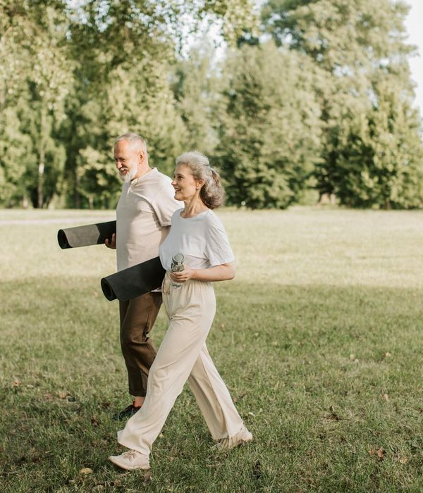 Woman smiling peacefully during a light stretching exercise outdoors.